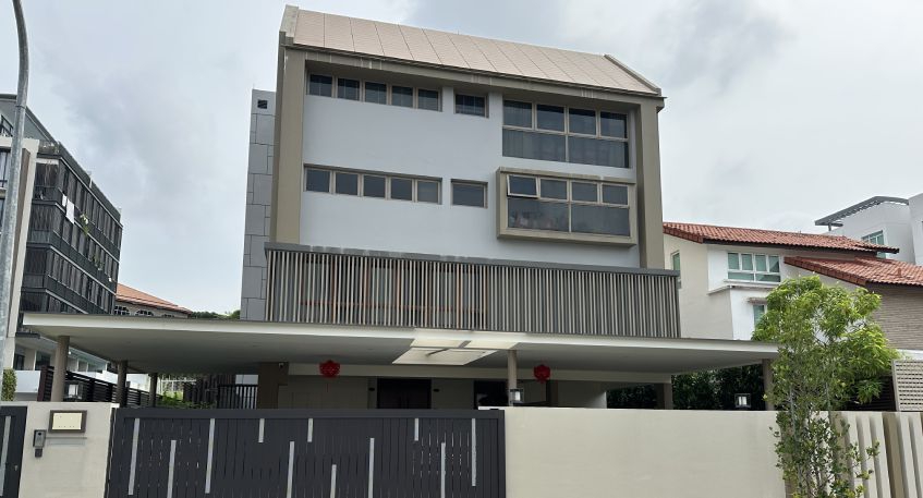 Modern multi-story house with a brown roof and a dark slatted fence.