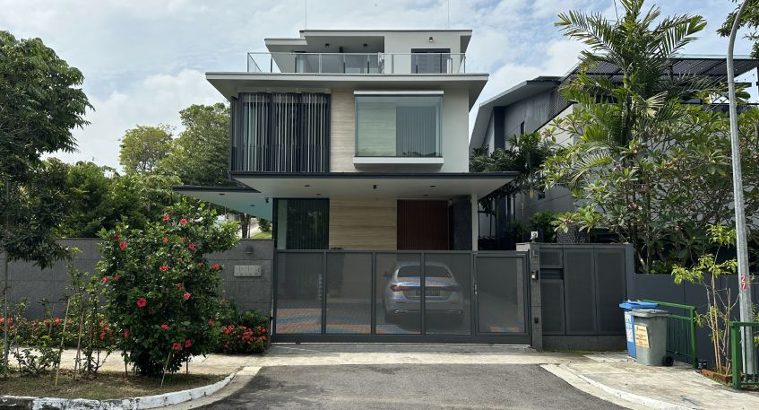 Modern house with grey gate and greenery.